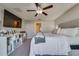 Spacious bedroom with a ceiling fan, TV, and decorative shelving for a comfortable and modern living space at 15403 Wicked Strong St, Sun City Center, FL 33573