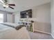 A cozy bedroom featuring a ceiling fan, TV, and shelving for comfortable living and easy organization at 15403 Wicked Strong St, Sun City Center, FL 33573