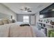 A bright bedroom with a ceiling fan, TV, shelving, and a plush bed for comfortable and modern living at 15403 Wicked Strong St, Sun City Center, FL 33573