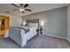 A well-lit bedroom features a ceiling fan, plush carpet, and closet access for a comfortable, modern retreat at 15403 Wicked Strong St, Sun City Center, FL 33573