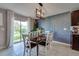 Stylish dining room features a modern light fixture, a geometric accent wall, and backyard views at 15403 Wicked Strong St, Sun City Center, FL 33573