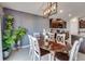 Dining area features modern light fixture, wainscoting feature wall, open floor plan to kitchen at 15403 Wicked Strong St, Sun City Center, FL 33573