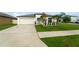 Beautiful single-story home featuring a tidy front lawn, a two-car garage, and mature landscaping at 15403 Wicked Strong St, Sun City Center, FL 33573