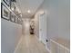 Long hallway with neutral paint, recessed lighting, and decorative wall art at 15403 Wicked Strong St, Sun City Center, FL 33573