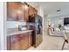 Well-lit kitchen with stainless steel appliances and wood cabinetry that offers ample storage space at 15403 Wicked Strong St, Sun City Center, FL 33573