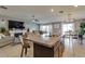 Open concept kitchen with large island, granite countertops, stainless steel sink, and adjacent dining area and living room at 15403 Wicked Strong St, Sun City Center, FL 33573