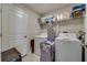 Organized laundry room equipped with washer, dryer, shelving, and storage at 15403 Wicked Strong St, Sun City Center, FL 33573