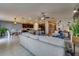 Bright living room featuring open layout, tile floors, kitchen, and comfortable gray sectional sofa at 15403 Wicked Strong St, Sun City Center, FL 33573