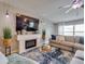 Cozy living room features fireplace, modern ceiling fan, and comfortable sectional sofa at 15403 Wicked Strong St, Sun City Center, FL 33573