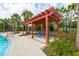 Shaded poolside pergola with lounge chairs at 15403 Wicked Strong St, Sun City Center, FL 33573