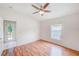Bright bedroom featuring a ceiling fan, wood floors, and a door to the outside at 1610 Stetson Dr, Wesley Chapel, FL 33543
