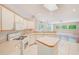 Bright kitchen featuring white cabinetry, an island, and an open view to the living area at 1610 Stetson Dr, Wesley Chapel, FL 33543