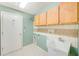 Laundry room featuring upper cabinets, utility sink, and tile flooring at 1610 Stetson Dr, Wesley Chapel, FL 33543