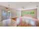 Open-concept living room with hardwood floors, sliding glass doors, and arched windows with natural lighting at 1610 Stetson Dr, Wesley Chapel, FL 33543