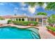 Stunning outdoor pool area featuring a screened-in patio and mature landscaping at 1610 Stetson Dr, Wesley Chapel, FL 33543