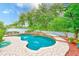Private backyard pool with a waterfall feature and lush greenery at 1610 Stetson Dr, Wesley Chapel, FL 33543