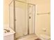 Bright bathroom featuring a glass-enclosed shower, tile flooring, and standard fixtures at 16511 Enclave Village Dr # 107, Tampa, FL 33647