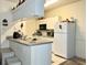 Compact kitchen featuring white cabinetry, modern appliances, and a functional breakfast bar at 16511 Enclave Village Dr # 107, Tampa, FL 33647