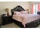Serene bedroom with a dark wood sleigh bed, matching nightstands, and plush bedding at 16511 Enclave Village Dr # 107, Tampa, FL 33647
