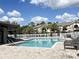 Resort-style pool area surrounded by lounge chairs, landscaping, and well-maintained white fencing at 16511 Enclave Village Dr # 107, Tampa, FL 33647