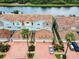 Aerial view of a residential complex with tile roofs and private parking with waterway in background at 1710 Lago Vista Blvd, Palm Harbor, FL 34685