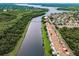 Waterfront townhomes overlook tranquil river surrounded by lush trees and a bridge leading into the distance at 1710 Lago Vista Blvd, Palm Harbor, FL 34685