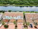 Aerial view of stylish townhomes featuring tile roofs, waterfront access and manicured landscaping at 1710 Lago Vista Blvd, Palm Harbor, FL 34685