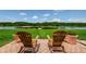 Backyard of the home offering a lake view with dock, lawn and a brick paver patio at 1710 Lago Vista Blvd, Palm Harbor, FL 34685