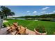 Charming backyard seating area showcasing scenic lake views and manicured lawn at 1710 Lago Vista Blvd, Palm Harbor, FL 34685