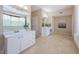 A spacious bathroom with double sinks, a soaking tub, a glass shower, and a large window for natural light at 1710 Lago Vista Blvd, Palm Harbor, FL 34685