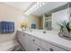 Bathroom featuring a long vanity with ample storage and a large, well-lit mirror at 1710 Lago Vista Blvd, Palm Harbor, FL 34685