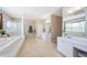 Primary bathroom with double vanity, separate shower, and soaking tub at 1710 Lago Vista Blvd, Palm Harbor, FL 34685
