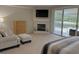 Bedroom featuring neutral decor, a fireplace, sitting area, balcony access and a view of the water at 1710 Lago Vista Blvd, Palm Harbor, FL 34685