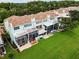 Aerial view of light blue condo buildings with tile roofs, screened lanais, and well-maintained lawns at 1710 Lago Vista Blvd, Palm Harbor, FL 34685