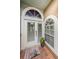 Charming front door with half-moon window, welcome mat, and tiled porch, for a warm and inviting entryway at 1710 Lago Vista Blvd, Palm Harbor, FL 34685