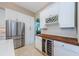 Kitchen features stainless steel refrigerator, wine rack, and beverage cooler at 1710 Lago Vista Blvd, Palm Harbor, FL 34685