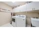The laundry room has a washer and dryer with plenty of cabinet space at 1710 Lago Vista Blvd, Palm Harbor, FL 34685