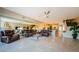 Spacious open-concept living room with tiled floors, leather couches, and access to the kitchen and backyard at 1710 Lago Vista Blvd, Palm Harbor, FL 34685