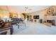 Bright open-plan living room with fireplace, neutral decor, and tile floors connects to the kitchen and staircase at 1710 Lago Vista Blvd, Palm Harbor, FL 34685