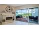 Living room view showcasing the outdoor brick patio, fireplace, furniture, and peaceful lake scenery at 1710 Lago Vista Blvd, Palm Harbor, FL 34685