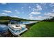 Scenic waterfront view with a boat docked on the lush, green shoreline, perfect for enjoying lakeside living at 1710 Lago Vista Blvd, Palm Harbor, FL 34685