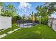 Landscaped backyard oasis with a small in-ground pool, artificial turf, and privacy fencing at 1720 Bayou Grande Ne Blvd, St Petersburg, FL 33703