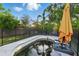 Backyard featuring a small, in-ground pool with a safety fence, an umbrella and tropical foliage at 1720 Bayou Grande Ne Blvd, St Petersburg, FL 33703