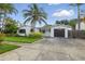 Charming single-story home with tropical landscaping, a driveway, and a one-car garage at 1720 Bayou Grande Ne Blvd, St Petersburg, FL 33703