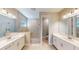 Spacious bathroom featuring dual vanities, a glass-enclosed shower, and a private toilet room, creating a luxurious retreat at 17714 Everlong Dr, Land O Lakes, FL 34638