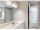 Bright bathroom with a large mirror, white vanity, and a view into a bedroom, creating an open and airy feel at 17714 Everlong Dr, Land O Lakes, FL 34638