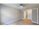 Bedroom with modern light fixture, wood floors, and glass doors leading to other rooms at 17714 Everlong Dr, Land O Lakes, FL 34638