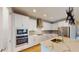 Modern kitchen with stainless steel appliances, island, quartz countertops, and backsplash at 17714 Everlong Dr, Land O Lakes, FL 34638