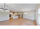 Spacious living room open to kitchen with modern light fixtures and light wood flooring at 17714 Everlong Dr, Land O Lakes, FL 34638