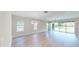 Bright, open-concept living room featuring hardwood floors and multiple windows with backyard views at 17714 Everlong Dr, Land O Lakes, FL 34638